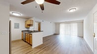Located at 480 Starling Ct in Wadsworth, Ohio, this single-floor, 2-bedroom, 1-bathroom home offers a practical and well-organized layout. The open-concept kitchen and living area form the heart of the home, with warm wood-look flooring running throughout. The kitchen features honey-toned cabinetry, dark granite-style countertops, a stainless steel sink, and stainless steel appliances including a range and dishwasher. A peninsula counter separates the kitchen from the living area, providing additional prep space and a natural division between the two zones. The living room is bright and airy, highlighted by a large sliding glass door with vertical blinds that allows generous natural light to flow in. A ceiling fan with light fixture adds comfort to the space. The primary bedroom is a comfortable size, complete with a ceiling fan, a window for natural light, and access to a spacious walk-in closet equipped with wire shelving on multiple walls for ample storage. The second bedroom also features hardwood-style flooring and a standard closet with a shelf and rod. The bathroom includes a full tub-shower combo, a vanity, and classic basketweave tile flooring. A hallway connects the private areas of the home, and the front entry opens directly into the main living space.