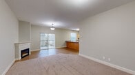 This single-floor residence offers a thoughtfully designed layout that balances open communal spaces with comfortable private areas. The open-concept kitchen is a central highlight, featuring light maple cabinetry, granite-look countertops, a peninsula with an integrated sink, and a full suite of stainless steel appliances including a refrigerator, range, and microwave. Durable wood-look laminate flooring runs throughout the main living areas, lending a clean, cohesive feel.

The living area is generously sized and filled with natural light from a sliding glass door that opens to an outdoor space, complemented by a ceiling fan overhead. Built-in wall shelving in the main area provides a functional and architectural detail. A dedicated hallway connects the living spaces to the bedrooms, which feature plush carpeting, ceiling fans, natural light from windows with blinds, and closet storage. The neutral, soft-toned walls throughout create a calm and versatile backdrop.

The bathroom is cleanly appointed with a full tub-shower combination, a wood-vanity with granite-style countertop, and wood-look flooring. Additional utility areas are also present, offering practical storage and flexible use. Overall, the space presents a clean, move-in-ready environment with consistent modern finishes.