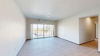 Located at 4415 E Longfellow Ave in Spokane, WA, this well-appointed 3-bedroom, 3-bathroom unit offers a thoughtfully designed single-level layout with a clean, contemporary aesthetic throughout. Light wood-style flooring flows seamlessly across the entire space, complemented by crisp white walls and dark-trimmed doors that add a modern contrast.

The open-concept kitchen and living area serves as the heart of the unit. The kitchen is equipped with full-height white shaker cabinetry, a white subway tile backsplash, stainless steel appliances including a refrigerator and gas range, and a large center island with pendant lighting overhead — ideal for both cooking and casual dining. The adjoining living room features large sliding glass doors that open to a private balcony, filling the space with natural light and providing outdoor views of the surrounding neighborhood.

Each of the three bedrooms features light flooring and neutral walls, with the primary bedroom offering generous proportions. The bathrooms maintain the same modern design language, with white cabinetry, black hardware accents, and clean finishes. A dedicated hallway connects the bedrooms, and an additional closet provides practical storage. The overall ambiance is bright, clean, and move-in ready.