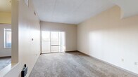 Located at 640 Wabash Avenue in Terre Haute, Indiana, this one-bedroom, one-bathroom unit offers a practical and comfortable single-floor layout. The combined living and dining area is generously proportioned, featuring neutral-toned carpet flooring, warm beige walls, and a textured ceiling. A pendant light fixture anchors the dining area, while large sliding glass doors flood the space with natural light and open directly onto a private balcony with open city views.

The kitchen is efficiently laid out with a double-basin sink, wood-toned cabinetry, and ample counter space, complemented by a pass-through that connects it to the living and dining area. A hallway leads to the bedroom, which is a well-sized private retreat with carpeted floors, a window allowing natural light, and access to multiple closets, including a double-door closet and an additional walk-in style storage space.

The bathroom is cleanly finished with tile flooring in a neutral stone tone, a single-sink vanity with wood cabinetry, a toilet, and a full tub-shower combination with a curtain rod. Throughout the unit, the neutral color palette and straightforward design provide a versatile canvas. Three closets total ensure strong storage capacity throughout the home.