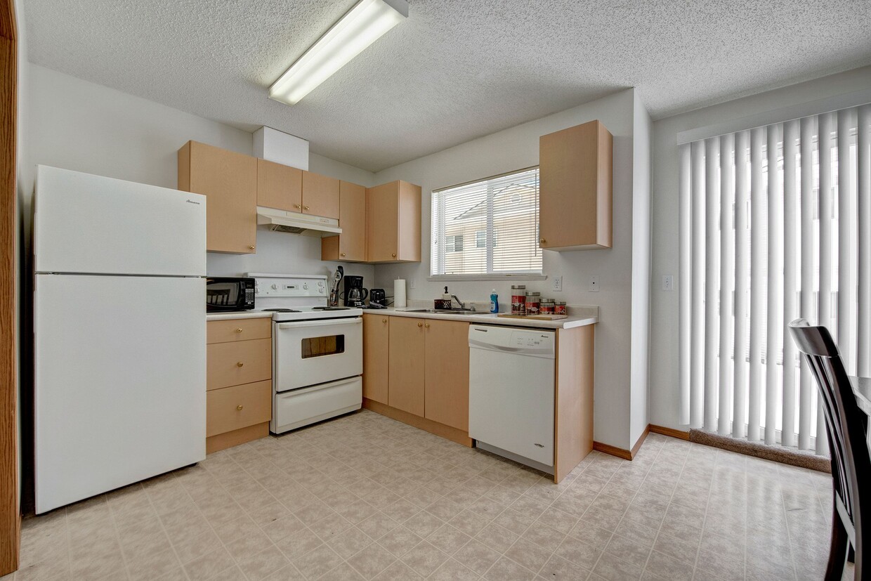 A kitchen with white appliances and light cabinetry - Ridgeview Village