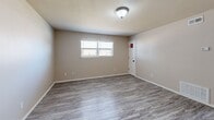 Located at 201 E Almar Dr in Chickasha, Oklahoma, this single-floor 2-bedroom, 1-bathroom home offers a practical and comfortable layout with a clean, neutral aesthetic throughout. The combined kitchen and living area serves as the heart of the home, where the kitchen features warm wood cabinetry lining both walls, granite-style countertops, a double sink, and white appliances including a range and refrigerator, complemented by light vinyl plank flooring that extends into the living area. Natural light filters in through windows fitted with horizontal blinds, adding brightness to the open space. A hallway connects the main living area to the private quarters of the home. Both bedrooms are carpeted and offer a comfortable sense of space, with windows that allow in natural light and views of the surrounding neighborhood. The primary bedroom is generously sized, providing ample room for furnishings. The full bathroom is well-appointed with a single vanity featuring warm wood cabinetry and granite-style countertop, a tub and shower combination, and tile-style flooring. Two closets provide convenient storage throughout the home. The consistent use of neutral tones and durable finishes gives the space a clean, move-in-ready feel.