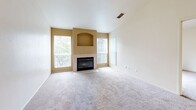 Located at 2651 Sunset Blvd in Rocklin, CA, this one-bedroom, one-bathroom residence offers a comfortable and functional single-floor layout. The living room serves as the heart of the home, featuring plush carpeting, vaulted ceilings, and large windows that flood the space with natural light. A tiled fireplace with a decorative arched niche above it serves as a striking focal point, adding warmth and character to the room. The kitchen is designed for efficiency, featuring a galley-style layout with light wood cabinetry, granite-toned countertops, tile flooring, and a full suite of white appliances including a range, microwave, refrigerator, and dishwasher. A peninsula counter connects the kitchen to the living area, creating an open and accessible flow. The spacious bedroom is finished with soft carpeting and includes a sliding glass door that opens directly onto a private wooden balcony, offering a pleasant outdoor retreat. The bedroom is complemented by a generous walk-in closet outfitted with wrap-around hanging rods and built-in shelving for ample storage. The bathroom features tile flooring and a full tub/shower combination, providing practical functionality in a clean, neutral finish.