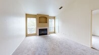 Located at 2651 Sunset Blvd in Rocklin, CA, this one-bedroom, one-bathroom residence offers a comfortable and functional single-floor layout. The living room serves as the heart of the home, featuring plush carpeting, vaulted ceilings, and large windows that flood the space with natural light. A tiled fireplace with a decorative arched niche above it serves as a striking focal point, adding warmth and character to the room. The kitchen is designed for efficiency, featuring a galley-style layout with light wood cabinetry, granite-toned countertops, tile flooring, and a full suite of white appliances including a range, microwave, refrigerator, and dishwasher. A peninsula counter connects the kitchen to the living area, creating an open and accessible flow. The spacious bedroom is finished with soft carpeting and includes a sliding glass door that opens directly onto a private wooden balcony, offering a pleasant outdoor retreat. The bedroom is complemented by a generous walk-in closet outfitted with wrap-around hanging rods and built-in shelving for ample storage. The bathroom features tile flooring and a full tub/shower combination, providing practical functionality in a clean, neutral finish.