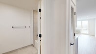 Located on the fifth floor at 337-339 Johnston Ave in Jersey City, NJ, Unit 503 is a thoughtfully designed studio that maximizes its efficient footprint through a clean, modern aesthetic. The single-level layout combines the kitchen and living area into one open space, promoting a versatile and functional arrangement.

The kitchen is a standout feature, outfitted with two-tone cabinetry—white upper cabinets paired with soft blue-gray lower cabinets—accented by matte black hardware. A textured tile backsplash, light quartz countertops, and stainless steel appliances including a gas range, built-in microwave, dishwasher, and refrigerator complete the space. A stacked washer and dryer unit is conveniently integrated nearby.

The living area is bright and open, featuring light hardwood flooring, recessed lighting, and crisp white walls. A large window frames views of the surrounding Jersey City neighborhood, allowing natural light to fill the room.

The bathroom is finished with large-format, light gray tiles extending from floor to ceiling around the soaking tub. A recessed niche provides practical storage, and clean grout lines contribute to the contemporary feel. The overall ambiance of the unit is modern, minimal, and move-in ready.
