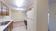 Located at 720 County Road B W in Roseville, MN, this one-bedroom, one-bathroom unit offers a practical and comfortable layout across a single floor. The living room is carpeted and generously sized, featuring a baseboard heating system and a wall-mounted air conditioning unit, ensuring year-round comfort. It flows openly toward the dining area and kitchen, which are combined into one functional space. The kitchen is equipped with a white refrigerator, an electric range, wood-toned cabinetry, and tile flooring, with a pendant light fixture above the dining area adding a simple, clean aesthetic. The bedroom is a well-proportioned retreat featuring soft carpeting, a ceiling fan with integrated lighting, a closet with sliding doors, a window offering natural light, and baseboard heating. The bathroom includes a full tub-shower combination with chrome fixtures and classic white tile flooring. Three closets throughout the unit provide ample storage. A hallway connects the main living areas, and a private balcony extends the living space outdoors. The unit's neutral color palette and textured ceilings give it a straightforward, move-in-ready character well-suited for comfortable everyday living.