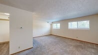 Located in Omaha, Nebraska, this compact, single-floor unit offers a well-organized layout designed to maximize every square foot. The open living area is finished with neutral wall-to-wall carpeting and a textured ceiling, creating a clean, understated aesthetic. Two windows along the exterior wall allow natural light to brighten the space and provide views of the surrounding neighborhood. The galley-style kitchen is efficiently arranged, featuring warm wood cabinetry on both sides, white appliances including a refrigerator, electric range, microwave, and dishwasher, complemented by durable wood-look vinyl flooring and ample counter space with an integrated sink. A peninsula counter separates the kitchen from the main living area, adding a sense of definition to each zone. The full bathroom is neatly appointed with wood-toned trim, vinyl flooring, a vanity with sink, toilet, and a full tub-shower combination. Two closets provide dedicated storage, helping to keep the living space tidy and organized. With a straightforward, functional design throughout, this unit in the 68106 zip code offers a practical and comfortable living environment.