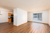 This single-floor residential unit offers a clean, functional layout with consistent warm-toned laminate flooring running throughout the entire space, complemented by white walls and textured popcorn ceilings that add a classic character.

The living area is open and well-proportioned, featuring a large sliding glass door with vertical blinds that allows natural light to fill the room while providing a view of the surrounding greenery. The space is bright, versatile, and ready to accommodate a variety of furniture arrangements.

The kitchen is thoughtfully designed with rich honey-toned wood cabinetry offering generous upper and lower storage. Dark granite-style countertops provide a practical contrast, and the space is equipped with a full suite of black appliances, including a range, microwave, dishwasher, and refrigerator. A window above the sink brings in additional natural light.

Additional rooms include a bedroom with ample wall space, natural light filtering through the windows, and the same durable laminate flooring found throughout the unit.

The bathroom features warm wood-toned cabinetry with a dark granite countertop, a glass-door shower stall, and hardwood-style flooring, creating a tidy and efficient space.

Overall, the unit presents a cohesive, low-maintenance aesthetic with practical finishes suited for comfortable everyday living.