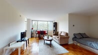 Situated at 2112 New Hampshire Avenue in Washington, D.C., this single-floor residence offers a thoughtfully designed layout that balances comfort and functionality. The open living and dining area serves as the heart of the home, featuring warm parquet hardwood flooring that adds timeless character throughout. A large picture window floods the space with natural light while framing lush green tree views, creating a bright and inviting atmosphere. The living area provides ample room for relaxed seating, while the adjacent dining space comfortably accommodates a dining set, making it ideal for everyday meals or entertaining.

The kitchen is efficiently designed with rich cherry wood cabinetry, dark granite countertops, tile flooring, and stainless steel appliances including a full-size refrigerator and dishwasher. The clean, practical layout maximizes functionality within the space.

The bathroom continues the design consistency found throughout the home, featuring matching cherry wood cabinetry topped with dark granite, a large vanity mirror, tile flooring, and a combined shower and closet area that offers convenient storage.

Overall, the residence presents a cohesive aesthetic with neutral wall tones, consistent finishes, and well-placed natural light, creating a comfortable and functional living environment in a prime Washington, D.C. location.