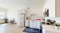 Located in Castle Rock, Colorado, this well-designed one-bedroom, one-bathroom residence at Meadowmark offers a clean, contemporary aesthetic throughout its thoughtfully laid-out single floor. Light wood-tone flooring runs continuously across all rooms, lending warmth and visual cohesion to the space.

The kitchen is a standout feature, equipped with a full suite of stainless steel appliances including a refrigerator, dishwasher, over-the-range microwave, and electric range. Crisp white cabinetry extends from floor to ceiling, providing generous storage, while light countertops complete the bright, modern look. A bold blue accent wall near the entry adds a pop of color and architectural interest to the open layout.

The living area benefits from tall ceilings and an abundance of natural light streaming through large windows that frame views of the surrounding Colorado landscape. The bedroom is a comfortable, well-proportioned room with its own large window offering ample daylight and outdoor views.

The bathroom features light wood flooring consistent with the rest of the unit, black matte hardware accents, and a clean, minimalist vanity. A dedicated closet provides practical storage. The overall ambiance is bright, modern, and move-in ready, making it a functional and stylish home in the Castle Rock community.
