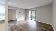 Located at Grand Pavilion Drive in Tampa, FL, this one-bedroom, one-bathroom unit offers a thoughtfully organized single-floor layout. Wood-look plank flooring runs consistently throughout the space, complementing the neutral gray tones of the walls and clean white trim, creating a cohesive and modern aesthetic.

The open living and dining area is bright and inviting, anchored by large sliding glass doors that flood the room with natural light and provide views of the surrounding greenery. A louvered closet door adds a functional storage element to the living space. The textured ceilings are present throughout the unit.

The galley-style kitchen is efficiently designed with white cabinetry, marble-look countertops, a stainless steel sink, and black appliances including a refrigerator, electric range, microwave, and dishwasher. It connects seamlessly to the dining area for ease of use.

The bedroom is a comfortable, well-proportioned retreat with a window that brings in natural light. It provides ample room for furnishings and connects conveniently to the rest of the unit via a hallway. Three closets throughout the unit offer generous storage capacity.

The bathroom features a white tub-shower combination, a marble-look vanity top with white cabinetry, and wood-look flooring. An in-unit laundry area adds everyday convenience to this practical Tampa residence.
