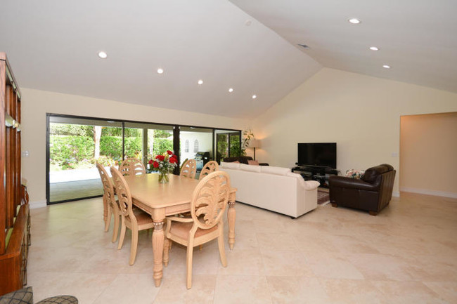 Open floor plan, vaulted ceilings - large sliding glass doors to covered outdoor patio and pool - 4100 NW 25th Way