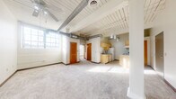 Located at 200 S Eighth St in Richmond, Indiana, this one-bedroom, one-bathroom unit offers a distinctive loft-inspired character that blends industrial design elements with comfortable living. The open-concept main area seamlessly integrates the living room, dining room, and kitchen, creating a generous, versatile space filled with natural light streaming through large, grid-pane windows. White-painted shiplap ceilings and exposed silver ductwork run throughout, lending an urban, industrial aesthetic to the interior. Ceiling fans in both the living area and bedroom provide added comfort. The kitchen is thoughtfully laid out in a galley style, featuring light wood cabinetry, ample counter space, a double-basin sink with a modern faucet, and white appliances including a refrigerator and electric range. The bedroom offers a cozy retreat with carpeted flooring, a ceiling fan, a closet with bi-fold doors, and a large window that bathes the room in natural light. The full bathroom includes a tub/shower combination, a single-sink vanity with cabinet storage, and tile flooring. With four closets spread throughout, storage is plentiful. The unit's open layout, industrial character, and warm wood accents create a unique and functional living environment.