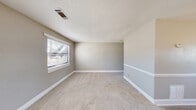 Located at 3 Fox Trace in Augusta, Georgia, this single-story, one-bedroom, one-bathroom home offers an efficient and functional layout across its single floor. Neutral gray walls, white baseboards, and textured ceilings are consistent throughout, creating a cohesive and clean aesthetic.

The living room is a welcoming space featuring soft carpeted flooring, a window with blinds that allows natural light to fill the room, and a direct entry door — making it both practical and bright. The kitchen is a galley-style space lined with warm wood-toned upper and lower cabinetry, light wood-look vinyl flooring, and includes a white electric range and a full-size refrigerator. A window above the sink and a rear entry door bring in additional natural light.

The bedroom is a cozy, carpeted room with a window for natural light and includes a closet with a hanging rod for storage. A connecting hallway provides access to the full bathroom, which features a tiled tub and shower combination with a window above for ventilation and light.

Throughout the home, textured ceilings, neutral tones, and consistent carpeting in the living and sleeping areas contribute to a uniform, easy-to-maintain interior. This home is well-suited for those seeking a simple, manageable living space in Augusta.