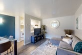 Located at 10785 E Exposition Ave in Aurora, Colorado, this efficiently designed one-bedroom, one-bathroom residence offers a thoughtful layout across a single floor. The living room serves as the heart of the space, featuring wood-style plank flooring, neutral gray walls, and a pass-through window that visually connects to the kitchen, enhancing the sense of openness. Natural light filters in through windows, contributing to a bright and welcoming atmosphere. A baseboard heater and a front entry door with exterior access round out the functional features of the living area.

The kitchen is compact yet practical, equipped with white cabinetry, a range, and essential appliances, all visible through the pass-through from the living room.

The bedroom is a standout space, distinguished by a bold teal accent wall that adds a striking pop of color. Plush carpeting, a closet with hanging storage, and a window allowing natural light make it a comfortable retreat.

The bathroom is clean and functional, featuring a full soaking tub with white tile surround and a window for ventilation. Throughout the residence, the design is cohesive and modern, making efficient use of every square foot for comfortable everyday living.