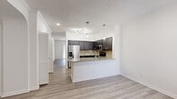 Located at 8181 El Mundo St in Houston, TX, this well-appointed one-bedroom, one-bathroom residence offers a thoughtfully designed single-floor layout. The open-concept kitchen and living area serves as the heart of the home, featuring light wood-style flooring, recessed lighting, and a stylish pendant light fixture. The kitchen is outfitted with dark espresso cabinetry, a travertine tile backsplash, stainless steel appliances — including a French door refrigerator, electric range, and built-in microwave — and a granite-topped breakfast bar that flows seamlessly into the living space. A hallway with louvered closet doors leads to the bedroom and bathroom. The generously sized bedroom is carpeted for comfort, features crown molding, a ceiling fan, and a window that brings in natural light. An elegant arched entryway opens to a walk-in closet outfitted with wire shelving systems for ample storage. The bathroom includes dark cabinetry for storage, a granite-style vanity top, and a soaking tub with a marble-style surround. Washer and dryer connections are also visible within the unit, adding everyday convenience to this practical and attractive Houston residence.
