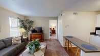 Located at 320 E West Pkwy in Anderson, South Carolina, this 1-bedroom, 2-bathroom residence offers a thoughtfully organized single-floor layout that makes excellent use of its space. The living room welcomes you with warm neutral tones, plush carpeting, and multiple windows that invite natural light, creating a bright and comfortable atmosphere for relaxing or entertaining. A small dining bar area provides a convenient spot for casual meals. The kitchen is well-appointed with classic white cabinetry, dark granite-style countertops, a dark tile backsplash, a gas range, and a refrigerator — all set atop hardwood-style flooring that adds warmth to the space. The bedroom is a comfortable retreat featuring plush carpeting, a ceiling fan with light fixture, and a window that brings in natural outdoor views. Two full bathrooms serve the home, each featuring granite-style countertops, white cabinetry, and clean, neutral finishes — one with a tub/shower combination and hardwood-style flooring. Three closets throughout the unit provide ample storage. Textured ceilings and neutral wall tones tie the entire space together, lending a cohesive and functional character throughout.
