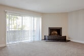 Located at 11772 Eighth Way N in Saint Petersburg, Florida, this single-story unit offers a well-organized layout that balances comfort and functionality. The living room serves as the focal point of the space, featuring plush wall-to-wall carpeting in a warm neutral tone, a textured ceiling, and a striking corner fireplace with a dark raised hearth that adds character to the room. A large sliding glass door fitted with vertical blinds fills the living area with natural light and provides access to an outdoor balcony with views of surrounding greenery.

The kitchen has been updated with white shaker-style cabinetry, granite-look countertops, and a full suite of stainless steel appliances, including a refrigerator, electric range, and dishwasher. Light wood-look flooring runs throughout the kitchen, and a skylight adds an additional source of natural illumination.

The bedrooms are carpeted and finished with the same neutral palette seen throughout the unit, with vertical blinds on the windows allowing for adjustable light control. The bathroom features light wood-look flooring, white cabinetry with granite-look countertops, a large mirror, and a tiled tub-shower combination, presenting a clean and cohesive aesthetic.