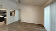 This 710-square-foot, single-story apartment at 5325 E Tropicana Ave in Las Vegas, NV offers a functional and modern layout across 2 bedrooms and 2 bathrooms. The open living area features wood-style plank flooring, a ceiling fan, and a sliding glass door with vertical blinds that fills the space with natural light and provides outdoor access. A pass-through opening connects the living room to the kitchen, enhancing the open feel. The kitchen is well-appointed with dark shaker-style cabinetry, white countertops, a subway tile backsplash, stainless steel appliances including a range, microwave, and refrigerator, a stainless steel sink, and recessed lighting. Both bedrooms are carpeted and include ceiling fans, windows with blinds offering outdoor greenery views, and dedicated closets. The textured ceilings are consistent throughout. Each bathroom is clean and modern, featuring wood-style flooring, a dark vanity with a white countertop, and a tiled shower-tub combination. Two additional closets provide practical storage throughout the unit, completing this efficient and updated Las Vegas residence.