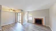 Located at 2302 South Goebbert Road in Arlington Heights, IL, this one-bedroom, one-bathroom residence offers a well-organized single-floor layout designed for comfortable everyday living. The combined kitchen and living room serves as the heart of the home, highlighted by a classic brick fireplace with a white-painted mantel — a standout architectural feature that adds warmth and character to the space. Hardwood-style flooring flows throughout the main living areas, complementing the neutral, light-toned walls. Sliding glass doors lead to a private balcony, allowing natural light to pour in alongside views of the surrounding greenery. A ceiling fan adds both function and style to the living area. The kitchen features warm wood cabinetry, a pass-through counter open to the living area, and a full suite of appliances including a coil-top range. The bedroom offers plush carpeting underfoot, a large window with outdoor views, and convenient access to both a closet and the full bathroom. The bathroom is equipped with a tub-shower combination fitted with white tile surround and stainless steel grab bars. A dedicated closet adds practical storage to complete this thoughtfully arranged home.