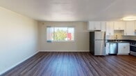 Located at 202 E 12th Street in Oakland, California, Unit C is a single-floor residence that combines modern updates with functional design throughout its thoughtfully laid-out living spaces.

The open-concept living and dining area is finished with durable hardwood-style flooring and neutral-toned walls that create a bright, welcoming atmosphere. A wall-mounted heater provides efficient climate control, and the space receives ample natural light through a large window framing views of the surrounding neighborhood and greenery.

The kitchen is well-appointed with crisp white shaker-style cabinetry, dark granite countertops, and a full suite of stainless steel appliances, including a gas range, refrigerator, and dishwasher. A sliding glass door adjacent to the kitchen opens to a private balcony overlooking the Oakland city skyline, offering an attractive outdoor extension of the living space.

The bedroom is carpeted for comfort and features a sliding mirrored closet, a ceiling fan with integrated lighting, and a window with views of the city skyline, filling the room with natural light.

The bathroom is finished with hardwood-style flooring, a white vanity with an undermount sink, a framed mirror with overhead lighting, and clean, classic fixtures throughout.

This unit offers a balance of updated finishes and practical amenities in a well-situated Oakland location.