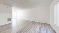 Located in Torrance, CA, this two-bedroom, two-bathroom home spans two floors with a functional and efficient layout. The main floor features a bright living room with wood-style plank flooring, a textured ceiling, ceiling fan, and a large window with vertical blinds that fills the space with natural light. The galley-style kitchen is outfitted with white cabinetry, dark countertops, an electric range, overhead ventilation hood, and a double-basin sink — all complemented by matching wood-style flooring. A full bathroom on this level features a white vanity with under-cabinet storage and a large mirror. The staircase connects to the upper floor, where both bedrooms are found. The primary bedroom offers a generous footprint, a sliding-door closet, and a window with natural light. The second bedroom also includes a closet and access to the stairwell hallway. The second full bathroom on the upper level features a soaking tub with tiled surround accented by a decorative mosaic border, a white vanity, and a bright window. Consistent wood-style flooring and a clean, neutral white palette flow throughout, lending the home a cohesive and move-in-ready feel.