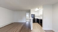 Located in Lynnwood, Washington, this one-bedroom, one-bathroom residence offers a well-designed single-level layout that maximizes every square foot of its compact footprint. The open-concept living, dining, and kitchen area forms the heart of the home, centered around a striking white-painted brick fireplace that serves as a focal point in the living room. Natural light filters in through multiple windows, brightening the space and complementing the warm-toned hardwood-style flooring that runs throughout the main areas.

The kitchen is efficiently designed with crisp white upper cabinetry, dark lower cabinets, black appliances including a full-size refrigerator and range, and a peninsula that provides additional prep space and separates the kitchen from the living area. A textured ceiling adds dimension throughout the unit.

The bedroom is a comfortable, carpeted retreat featuring a double-door closet and a window with exterior views, along with baseboard heating for year-round comfort. The bathroom includes a full soaking tub and shower combination. Additional practical features include two closets for storage, a dedicated laundry area with an in-unit water heater, and convenient access from the front entry.