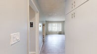 Located in the Eagle Rock neighborhood of Los Angeles, this efficient one-bedroom, one-bathroom unit offers a practical and comfortable single-floor layout. Light tile flooring runs consistently throughout the space, lending a clean, cohesive look to every room. The combined living and dining area is bright and open, with a large window dressed in vertical blinds that filters natural light and provides views of the surrounding greenery. A wall heater unit provides climate control in the living space. The bedroom offers a generous footprint with its own window, continuing the tile flooring and neutral wall palette for a calm, restful atmosphere. The kitchen is well-equipped, featuring rich dark wood cabinetry, a mosaic tile backsplash, light stone countertops, a double-basin stainless steel sink, and stainless steel appliances including a refrigerator, range, and over-the-range microwave. The bathroom includes a tub-shower combination with a glass sliding door, a vessel-style sink atop a dark vanity, and tile flooring. Three closets throughout the unit provide notable storage capacity. Textured ceilings are present throughout. This unit offers a functional and inviting layout well-suited for comfortable everyday living.