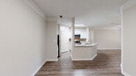 Located at 156 Bethesda Church Rd in Lawrenceville, GA, this single-floor, three-bedroom, two-bathroom home offers a well-designed layout with a comfortable, functional flow throughout. The open-concept living and kitchen area serves as the heart of the home, featuring rich hardwood-style flooring, crown molding, and neutral warm-toned walls that create a clean, welcoming ambiance. The kitchen is equipped with stainless steel appliances including a refrigerator, microwave, and range, complemented by white cabinetry, granite-look countertops, and a peninsula with a sink — ideal for both cooking and casual dining. The living area receives natural light through large windows and is finished with a ceiling fan. The generously sized primary bedroom offers plush carpeting, a ceiling fan, natural light, and access to a walk-in closet with built-in wire shelving and organizational units. The additional bedrooms also feature carpet flooring and natural light from exterior-facing windows. The bathrooms are finished with wood-style flooring, white vanities, granite-look countertops, and a tiled tub-shower combination. Two hallways connect the spaces efficiently, rounding out a thoughtfully arranged and move-in-ready home.