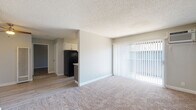 Located at 1600 Aster Dr in Antioch, California, this single-story residence offers a functional and well-maintained layout with a clean, neutral aesthetic throughout. The open living area is finished with plush carpeting and features a large sliding glass door dressed with vertical blinds, allowing abundant natural light to fill the space. A textured ceiling adds a classic touch that carries through the main living areas. The living space flows seamlessly toward the kitchen, which is outfitted with gray lower cabinets, white upper cabinetry, light quartz-style countertops, and wood-look vinyl plank flooring. A tall window in the kitchen frames an outdoor view of lush, flowering landscaping, brightening the workspace naturally. Black appliances, including a refrigerator and range, provide a contrasting accent to the light cabinetry. The bedroom offers generous proportions with soft carpeting, neutral gray walls, and a window with vertical blinds for light control and privacy. A ceiling fan adds comfort to the space. The bathroom is finished with wood-look luxury vinyl flooring, a gray vanity with a light countertop, and a full tub and shower combination with a curved curtain rod. Brushed nickel fixtures and hardware provide a cohesive, modern finish throughout.