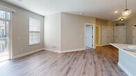 Located at 950 Jordan Creek Parkway in West Des Moines, Iowa, this well-appointed 1-bedroom, 2-bathroom unit offers a thoughtfully designed single-floor layout. The kitchen stands out as a centerpiece of the home, showcasing soft gray shaker-style cabinetry that extends to the ceiling, a white quartz island with an undermount sink, stainless steel appliances, a subway tile backsplash, and a built-in wine rack alongside a convenient desk nook. Light wood-look flooring flows throughout the main living and kitchen areas, adding warmth and continuity. The spacious bedroom features plush carpeting, natural light through double windows, and a ceiling fan for added comfort. The primary bathroom is elegantly finished with a dual-sink vanity, shaker-style cabinetry with matte black hardware, large-format tile flooring, and a tiled soaking tub and shower combination — with a dedicated walk-in closet adjacent. A second bathroom provides additional convenience. The living area benefits from natural light and connects seamlessly to a private balcony, offering views of the modern multi-story building exterior. Neutral, soft-tone walls throughout create a clean, contemporary ambiance suited for a variety of styles.