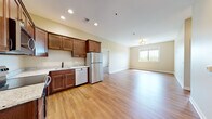 Located at 204 N Fourth St in DeKalb, IL, this single-floor unit offers a thoughtfully designed, open-concept layout finished with warm, neutral tones throughout. Rich hardwood-style flooring flows seamlessly across the living, kitchen, and bedroom areas, creating a cohesive and inviting atmosphere.

The kitchen is well-appointed with rich espresso-toned cabinetry, light granite countertops, and a full suite of stainless steel appliances, including a refrigerator, range, microwave, and dishwasher. The kitchen opens directly into the spacious living area, which benefits from a large window that fills the space with abundant natural light and provides pleasant outdoor views.

The bedroom is generously sized, featuring its own large window and a walk-in closet with built-in shelving, offering ample storage. A well-lit hallway connects the main living spaces and leads to the bathroom, which is a standout feature of the unit. The bathroom is finished with large-format, marble-look white tiles on both the floors and walls, complemented by matte black hardware. A glass-enclosed walk-in shower, a wood-toned vanity with a granite countertop, and a framed mirror complete the refined aesthetic.

The entryway, marked by a bold blue door, provides a welcoming and secure entry point into the space.