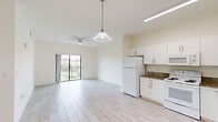 Located in Homestead, FL, this single-floor, 4-bedroom, 2-bathroom residence offers a bright and functional layout designed for comfortable living. Light-toned wood-look tile flooring runs throughout the entire home, creating a cohesive and clean aesthetic.

The open-concept living and kitchen area serves as the heart of the home. The kitchen is well-equipped with white cabinetry, granite-style countertops, and white appliances including a refrigerator, range, microwave, and dishwasher. A in-unit washer is also conveniently located near the kitchen entry. The living area is complemented by a ceiling fan and a sliding glass door that opens to a private balcony, allowing natural light to flow in and providing pleasant outdoor views.

The four bedrooms are bright and neutral, with light walls and tile flooring. The primary bedroom features mirrored sliding closet doors, adding to the sense of space. Additional bedrooms offer ample room and easy access to the hallway.

Both bathrooms are finished with wood-look tile floors and include a full tub-shower combo with white tile surround and modern chrome fixtures. A vanity with a dark countertop and mirror completes the bathroom design.

A hallway connects all rooms efficiently, and a dedicated closet provides additional storage throughout this well-organized home.