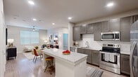 Located at 11918 Clay Road in Houston, TX, this single-story residence offers a thoughtfully designed 2-bedroom, 2-bathroom layout across a comfortable footprint. The open-concept floor plan seamlessly connects the kitchen and living room, creating an inviting and functional living space. The kitchen is a standout feature, equipped with stainless steel appliances, rich gray cabinetry, a subway tile backsplash, granite countertops, and a central island with bar seating — ideal for both cooking and entertaining. The living room receives natural light through large windows and is outfitted with a ceiling fan, complemented by warm wood-style flooring that flows throughout the home. Both bedrooms are well-sized, featuring neutral tones, wood-style flooring, and ceiling fans, with the primary bedroom offering a spacious walk-in closet with wire shelving. The primary bathroom includes a double-sink vanity with granite countertops, dark cabinetry, and modern fixtures. A second closet provides additional storage. The dedicated laundry area includes a full-size washer and dryer. Recessed lighting and a clean, neutral palette give the entire residence a modern, move-in-ready feel.