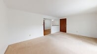 Located at 1392 Nash Rd in North Tonawanda, NY, this single-floor, 2-bedroom, 1-bathroom home offers a straightforward and functional layout. The living area is generously proportioned, featuring neutral carpet flooring, bright white walls, and a front entry door with direct access. An open passage connects the living space to the kitchen, which is laid out in a classic galley style. The kitchen is well-equipped with rich dark wood cabinetry, light countertops, a stainless steel sink, white appliances including an electric range and refrigerator, a tile backsplash, and wood-look flooring — all illuminated by a ceiling light and a window with natural light.

The spacious primary bedroom offers warm rose-toned carpet, clean white walls, a double-door closet, and a baseboard heating unit. A window provides views of the surrounding neighborhood. The second bedroom is similarly finished with carpeting, a window with blinds, and a baseboard heater. The bathroom features a full tub-shower combo with white tile surround, chrome fixtures, a small privacy window, wood flooring, and clean white finishes throughout. This home offers a comfortable and practical living environment in a residential North Tonawanda neighborhood.