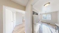 Located at 1452 Village Ln in Ypsilanti, Michigan, this one-bedroom, one-bathroom residence offers a well-organized single-floor layout designed for comfortable, everyday living. The floor plan connects an entrance and hallway to each of the home's distinct spaces, creating a functional and intuitive flow throughout.

The living room is a bright, open area featuring light hardwood flooring, neutral gray walls, and multiple windows with vertical blinds that invite generous natural light. A wall-mounted air conditioning unit and a baseboard heating system provide year-round climate control.

The galley-style kitchen is efficiently arranged with gray cabinetry lining both walls, white countertops, and a stainless single-basin sink. White appliances — including a coil-burner electric range with overhead ventilation and a full-size refrigerator — complete the space. Hardwood flooring and a ceiling light fixture add warmth and practicality.

The bedroom is a generously sized, carpeted retreat featuring soft neutral tones, a window with vertical blinds, and a baseboard heater. The room offers ample space and connects conveniently to the rest of the home.

The full bathroom features a clean, white-tiled tub and shower combination, a standard toilet, and a straightforward, functional design with neutral wall tones. Throughout, the residence maintains a clean, move-in-ready aesthetic.