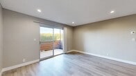 Located in San Bernardino, CA, this single-floor, one-bedroom, one-bathroom unit offers a clean and modern living experience with thoughtfully updated finishes throughout. Light wood-style flooring flows consistently across every room, creating a cohesive and bright aesthetic.

The open kitchen and living area serves as the heart of the unit. The galley-style kitchen is outfitted with white shaker cabinetry, dark quartz countertops, black appliances including a range and refrigerator, and recessed lighting — a practical and stylish space for everyday use. The adjoining living area is spacious and sun-filled, highlighted by a sliding glass door that opens to a private outdoor patio, allowing natural light to pour in and greenery to be enjoyed from within.

The bedroom is a comfortable, well-proportioned retreat featuring a ceiling fan with light fixture, a window fitted with vertical blinds for light control, and neutral taupe-toned walls that carry throughout the home.

The bathroom is neatly appointed with a white shaker vanity, dark quartz countertop, an undermount sink, and framed mirrors with brushed nickel fixtures. A hallway connects the main living areas to the bedroom and bathroom, with a dedicated closet offering additional storage. The textured ceilings and recessed lighting add functional polish to the overall design.