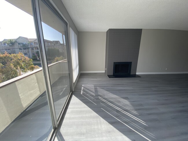 11858 Goshen Ave Unit 207 living room with fireplace and view - The Brentwood Collection