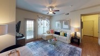 Located at 20900 FM-1093 W in Katy, TX, this single-story residence offers a thoughtfully designed layout with comfortable living spaces and quality finishes throughout. The living room is a welcoming, open area featuring wood-style flooring, a ceiling fan, and large windows with access to an outdoor door, allowing natural light to fill the space and creating a bright, relaxed atmosphere. The kitchen is well-equipped with rich wood cabinetry, granite-style countertops, a full suite of appliances, and a wood-look floor, providing ample workspace and storage for everyday living. The primary bedroom is generously sized, featuring plush carpet, a ceiling fan, large windows with decorative curtains, and a spacious walk-in closet with built-in shelving. The en-suite primary bathroom offers a dual-sink vanity with rich wood cabinetry, tile flooring, and a soaking tub with a shower curtain. A secondary bedroom is equally comfortable, with carpet, natural light from windows, and convenient closet access. An additional full bathroom features both a soaking tub and a separate glass-enclosed shower stall, finished with tile surround and tile flooring. Throughout the residence, arched doorway details and neutral tones contribute to a cohesive and welcoming interior aesthetic.