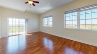 Located at 103 Patriot Dr in Middletown, Delaware, this single-floor residence offers a well-designed layout with a warm, consistent aesthetic throughout. Rich hardwood flooring flows seamlessly across every room, creating a cohesive and inviting atmosphere from entry to exit.

The open living area is a standout space, featuring a ceiling fan with light fixture and a tray ceiling detail that adds architectural interest. A pass-through counter connects the living area to the kitchen, which is appointed with crisp white shaker-style cabinetry, granite countertops with subtle veining, and stainless steel appliances including a gas range, over-the-range microwave, and refrigerator.

The bedrooms are generously sized, each equipped with ceiling fans and large windows that invite abundant natural light and provide views of the surrounding landscape. One bedroom includes a sliding glass door opening to an outdoor balcony. Built-in double closets provide ample storage in the secondary bedroom.

The bathrooms are elegantly finished with marble-look tile surrounds in the tub-shower combinations, complemented by white vanity cabinetry and granite-topped counters. Clean white trim and soft neutral wall tones throughout the home contribute to a bright, move-in-ready presentation.