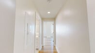 Located at Sandbar - Atlantic in Virginia Beach, this 2-bedroom, 1-bathroom unit offers a bright, modern interior defined by light wood flooring, neutral walls, and an abundance of natural light throughout. The open-concept kitchen and living area serves as the heart of the space, featuring crisp white shaker cabinetry, stainless steel appliances, a herringbone tile backsplash, and a freestanding island ideal for dining or meal prep. A sliding glass door opens directly to a balcony, framing unobstructed views of the Atlantic Ocean and Virginia Beach shoreline — a striking feature visible from both the kitchen and living area.

The two bedrooms are well-proportioned and finished consistently with the rest of the unit. The primary bedroom offers direct oceanfront views through a large window, while the second bedroom overlooks the surrounding coastal streetscape. Both rooms benefit from generous natural light via roller shade-equipped windows and continue the light wood flooring found throughout. A walk-in closet with built-in hanging rods provides practical storage.

The bathroom features a classic black-and-white mosaic tile floor, a white vanity with ample cabinetry, and a clean, functional layout. The unit's overall design is cohesive and contemporary, emphasizing clean lines, coastal light, and seamless indoor-outdoor connection.