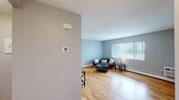 Located at 211 Main St in Farmington, CT, this one-bedroom, one-bathroom residence offers a thoughtfully organized single-floor layout. Warm hardwood flooring flows throughout the main living areas, lending a cohesive and inviting feel to the space.

The living room is generously proportioned, featuring soft gray walls, large windows with vertical blinds that invite natural light, and baseboard heating. The open feel makes it well-suited for both relaxing and entertaining.

The kitchen is well-appointed with crisp white cabinetry, dark granite-style countertops, stainless steel appliances including a refrigerator and range, and a stainless steel sink. A pass-through counter connects to an adjacent dining area, while windows and a door provide natural light and outdoor access.

The bedroom is a comfortable retreat, featuring hardwood flooring, soft neutral walls, a wide window overlooking greenery, a closet, and baseboard heating. The room accommodates a king-sized bed with ease.

The bathroom is clean and functional, featuring a granite-topped vanity with white cabinetry, a tub and shower combination with a curved curtain rod, and tiled flooring. An entrance area completes the layout, providing a practical transition into the home.