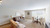 Located at 1217 E Prairie Brook Dr in Palatine, IL, this single-floor residence offers a thoughtfully laid-out interior with a calm, neutral aesthetic throughout. The open-concept living and dining area serves as the heart of the home, featuring wall-to-wall carpeting in a warm beige tone that contributes to the inviting atmosphere. A large window in the dining area allows natural light to filter in, offering views of the outdoors and brightening the combined space. The living area provides generous room for seating arrangements, complemented by soft, neutral wall tones that create a cohesive and relaxing environment.

The kitchen is efficiently designed with oak-toned cabinetry, white countertops, and white appliances, including a range and refrigerator. Ample cabinet storage is provided both above and below the countertops.

The bedroom is a serene retreat, finished in the same soft neutral palette with carpeted flooring and warm ambient lighting. An additional room provides flexible space suitable for various uses.

The bathrooms are clean and functional, each featuring a white vanity with cabinet storage underneath, a mirrored medicine cabinet with overhead lighting, and tile flooring. One bathroom includes a stand-up glass-enclosed shower, adding a practical touch to the overall layout.