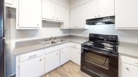 Located at 2564 Lumpkin Rd in Augusta, Georgia, this single-floor home offers a straightforward and functional layout designed for comfortable everyday living. The interior features a mix of wood-look flooring and soft carpeting that carries through the living and bedroom areas, creating a warm and welcoming feel.

The kitchen is efficiently designed with ample white cabinetry providing generous storage space above and below the counters. A double-basin stainless steel sink, gray laminate countertops in an L-shaped configuration, and a black electric range with overhead ventilation make this kitchen both practical and well-equipped for daily use.

The bedrooms are carpeted and bright, featuring vertical panel accent walls that add a subtle textural detail to the rooms. Each bedroom benefits from windows fitted with blinds, allowing for natural light while maintaining privacy. The textured ceilings and crown molding contribute a classic finishing touch throughout these spaces.

The bathroom is neatly appointed with a white vanity cabinet, a gray countertop with an inset oval sink, and a framed mirror positioned between two windows that invite in abundant natural light. Wood-look flooring ties the bathroom together with the rest of the home.

Overall, this home presents a clean, move-in-ready environment with a practical layout suited for a variety of lifestyles.
