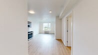 This well-designed one-bedroom, one-bathroom apartment at 1145 SW 170th Ave in Beaverton, Oregon offers a thoughtfully laid-out single-floor living space with a clean, contemporary aesthetic. Light wood-tone flooring flows seamlessly throughout, complementing the bright white walls and creating a warm, cohesive feel.

The open-concept kitchen and living area serves as the heart of the unit. The kitchen is outfitted with warm wood-grain cabinetry — both upper and lower — paired with a white tile backsplash and light countertops. A full suite of stainless steel appliances includes a refrigerator, range, built-in microwave, and dishwasher, providing a fully functional cooking space.

The bedroom is a comfortable, well-proportioned room featuring a large window with views of the surrounding Beaverton neighborhood, allowing ample natural light. A wall-mounted HVAC unit and smart thermostat are also present, offering convenient climate control.

The bathroom features matching wood-grain cabinetry, a vanity, and a walk-in shower area with clean white walls and recessed lighting. An in-unit laundry area includes a stacked Samsung washer and dryer alongside overhead wire shelving for additional storage. The unit offers a practical, modern living experience in a convenient Beaverton location.