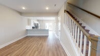 Located at 814 Memorial Blvd in Murfreesboro, Tennessee, this two-story home offers a well-designed layout with modern finishes throughout. The main floor centers around an open-concept living and kitchen area, where warm hardwood-style flooring flows seamlessly from the living space toward the kitchen. The kitchen is appointed with crisp white shaker cabinetry, granite-look countertops, a subway tile backsplash, and a full suite of stainless steel appliances including a refrigerator with ice maker, electric range, microwave, and dishwasher. Pendant lighting hangs above the kitchen peninsula, which provides additional seating and prep space. French doors at the rear of the main floor allow natural light to fill the space. A staircase with wood-topped steps and white balusters connects the floors. Upstairs, the bedrooms feature plush carpeting, ceiling fans, and windows that bring in natural light. The bathrooms are finished with clean white tub-shower combinations and brushed nickel fixtures. A generously sized walk-in closet with wire shelving provides ample storage. The overall aesthetic is clean, neutral, and move-in ready.