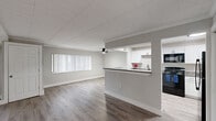 This renovated one-bedroom, one-bathroom unit in Southfield, Michigan offers a thoughtfully updated interior with a clean, modern aesthetic. The open-concept living and kitchen area serves as the heart of the home, featuring light wood-style flooring, neutral gray walls, and a ceiling fan overhead. Large windows with vertical blinds allow natural light to fill the space, creating a bright and airy atmosphere.

The kitchen is well-appointed with white shaker-style cabinetry, granite countertops, and a full suite of black appliances including a refrigerator, range, microwave, and dishwasher. A peninsula with a granite overhang connects the kitchen to the living area, providing additional counter space and a casual dining option.

The bedroom is carpeted for comfort and features multiple windows, a dedicated closet with built-in shelving, and a flush-mount light fixture. Crown molding and a shiplap-style ceiling add a refined architectural touch to the room.

The bathroom has been updated with a white vanity, mirrored medicine cabinet, and matte black hardware and fixtures, lending a contemporary feel. Throughout the unit, crisp white trim, six-panel doors with matte black handles, and consistent finishes reflect the quality of the renovation.