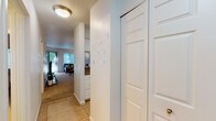This single-floor residence offers a thoughtfully designed layout that balances comfort and functionality. The entryway, finished with tile flooring, leads into the heart of the home, where the living and dining areas connect seamlessly. The living room is carpeted and bathed in natural light from large windows with vertical blinds that offer views of lush greenery outside, creating a bright and welcoming atmosphere. A sliding glass door further enhances the connection to the outdoors.

The dining area features plush carpet, an elegant chandelier overhead, and a pass-through opening to the kitchen, making it ideal for both casual meals and entertaining. The kitchen is well-equipped with stainless steel appliances, white shaker-style cabinetry, granite-style countertops, and tile flooring, offering both style and practicality.

The two bedrooms are carpeted and include sliding closet doors, providing ample storage. Each room is generously proportioned with clean, neutral walls that allow for personalized décor. The hallway leads to two bathrooms, each featuring tile floors, vanities with granite-style countertops, and bright overhead lighting, ensuring convenience for residents and guests alike. Overall, the space presents a clean, cohesive aesthetic throughout.