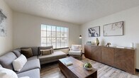 Located at 1805 IH-35 N in San Marcos, Texas, this one-bedroom, one-bathroom unit offers a well-organized layout across a single floor, making efficient use of every square foot. Light-toned wood-look flooring runs continuously throughout, creating a cohesive and clean aesthetic.

The living room serves as the heart of the unit, anchored by a large multi-pane window that draws in abundant natural light and provides views of the surrounding area. Textured ceilings add character to the space.

The galley-style kitchen is thoughtfully designed with dark cabinetry accented by gold hardware, light granite countertops, white subway tile backsplash, and ample storage on both sides of the corridor-style layout. A hallway connects the main living areas to the private spaces, maintaining a logical and functional flow.

The bedroom is a comfortable retreat, featuring a ceiling fan, a generously sized window for natural light, and bold dark-trimmed doors with gold hardware that add a modern contrast to the neutral walls. The bathroom includes a tub-shower combination with a curved curtain rod, a dark vanity with a white countertop, and gold fixtures that tie together the unit's consistent design language.

Overall, the unit presents a modern, cohesive aesthetic with warm tones and contemporary finishes throughout.