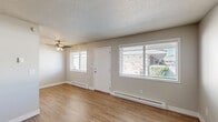 Located at 7806 NE 12th St in Vancouver, Washington, this single-floor, 2-bedroom, 1-bathroom home offers a practical and functional layout. The living room features wood-look laminate flooring, a textured ceiling, a ceiling fan, and large windows that allow natural light to fill the space while providing views of the surrounding greenery. Baseboard heating is found throughout the home. The combined dining and kitchen area continues the wood-look flooring and includes warm-toned wood cabinetry with ample upper and lower storage, a double-basin sink, gray laminate countertops, and white appliances including a refrigerator, range, and dishwasher. A ceiling fan with lighting adds to the comfort of this space. Both bedrooms are carpeted and feature textured ceilings and closets with sliding doors and built-in shelving. The primary bedroom offers a comfortable footprint with a window for natural light. The full bathroom is equipped with a tub-shower combination unit featuring built-in shelving and a grab bar. Additional highlights include three closets, a utility room, and a hallway connecting the main areas of the home, providing well-organized and efficient use of the overall floor space.
